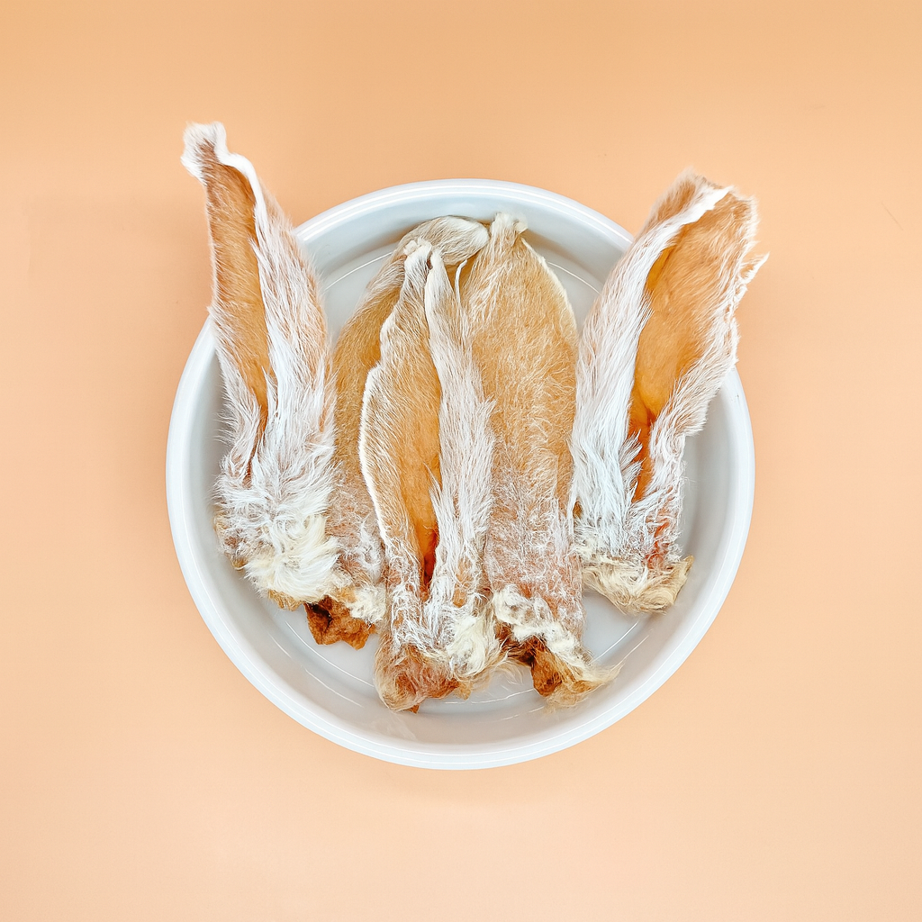 A round white plate displays four fur-on Rabbit Ears, artfully arranged with the fur side up against a beige background.